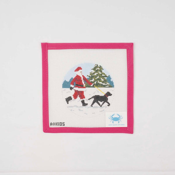 Sporty Santa walking a black Labrador