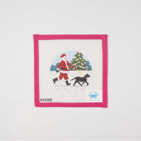 Sporty Santa walking a black Labrador